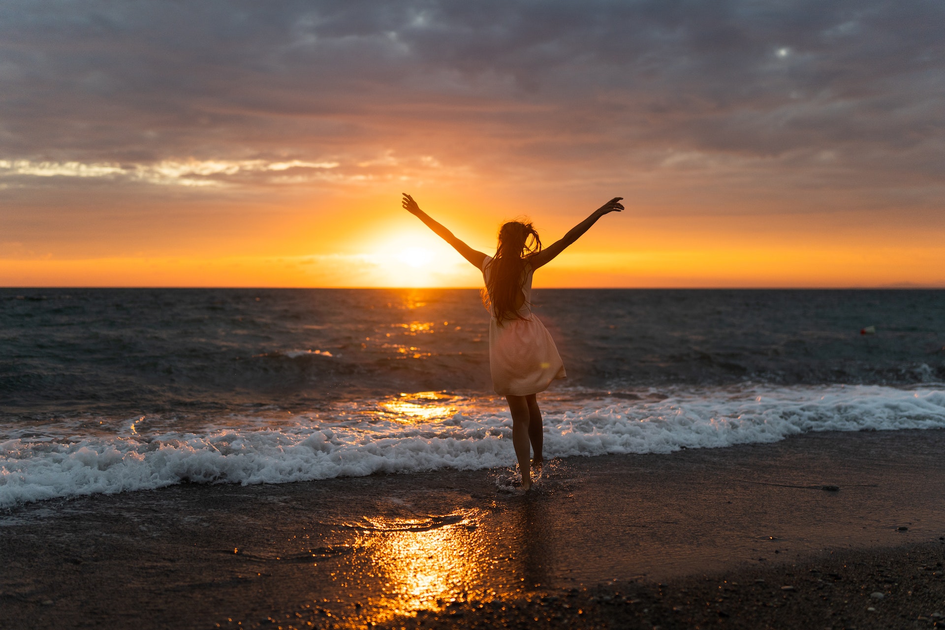 A person standing on a mountaintop, arms raised in triumph, symbolizing the journey of self-discovery and finding life's purpose amidst the beauty of nature.