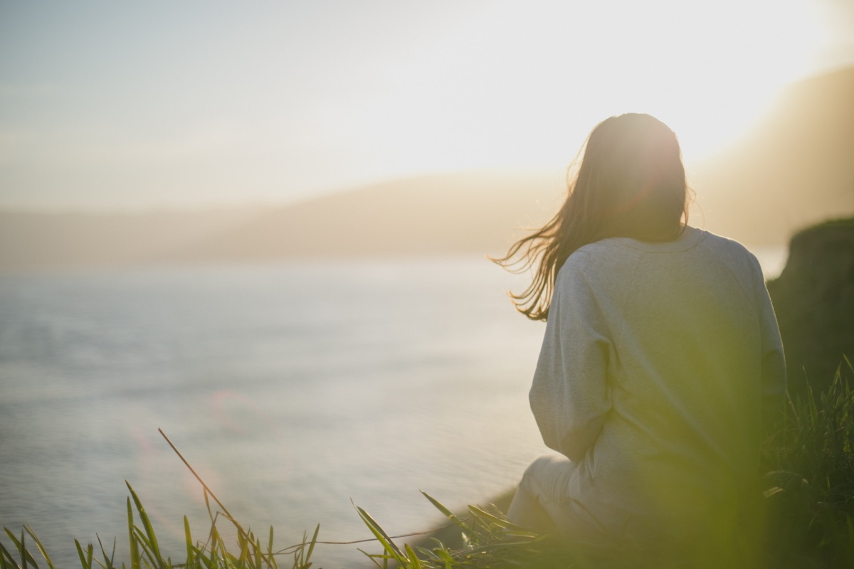 a girl sitting near river depicting the gift of mindfulness