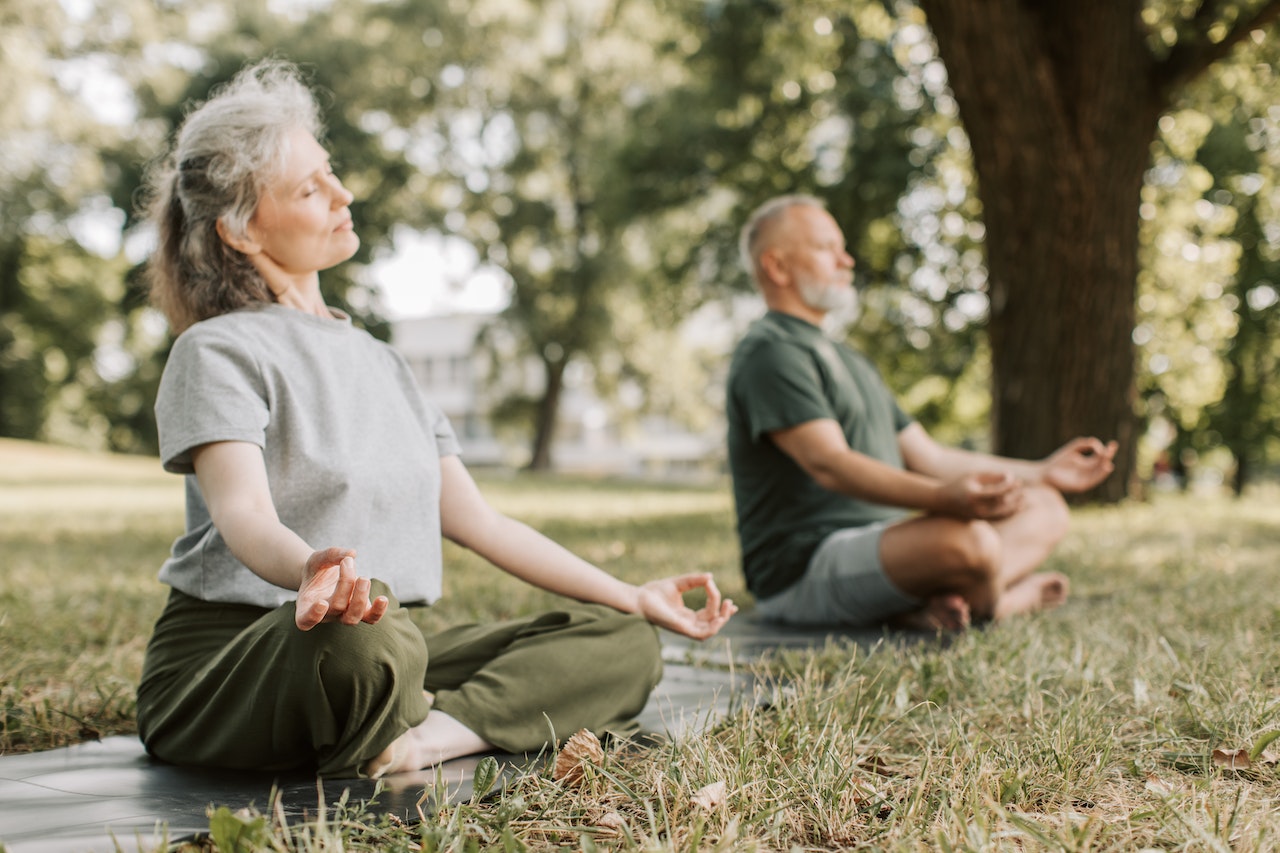 old couple doing yoga showing importance of mindful aging.